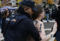 Policista zadržuje členku hnutí Femen na manifestaci v Madridu.